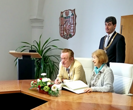 Herr Glöckner trägt sich ins Goldene Ehrenbuch ein