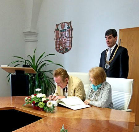 Herr Glöckner trägt sich ins Goldene Ehrenbuch ein